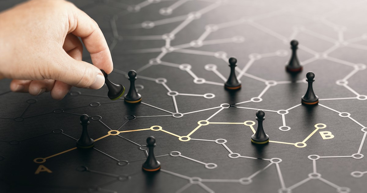 A person moving pawns in a strategic planning way